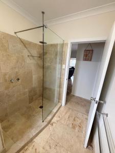 a bathroom with a shower with a glass shower stall at Three Fifty Four Straight St Hat Head - Bring your own linen. in Hat Head +6 photos