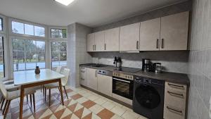 a kitchen with a table and a stove and a dishwasher at Fewo-OPR de Billi in Wusterhausen