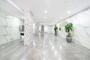 a lobby with white marble walls and potted plants at Spacious Sea-View Penthouse + Big Balconies in Ashdod