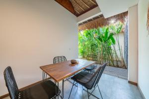 a dining room with a wooden table and chairs at La Reserva Villas Bali in Jimbaran