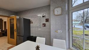 a kitchen with a table and a clock on the wall at Fewo-OPR de Billi in Wusterhausen +10 photos