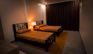 a room with two beds and a lamp in it at Balay Salazar in Malolos