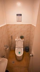 a bathroom with a toilet with a sign on the wall at Balay Salazar in Malolos