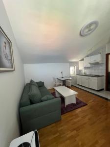 a living room with a green couch and a table at Apartment Zelenčić in Kali