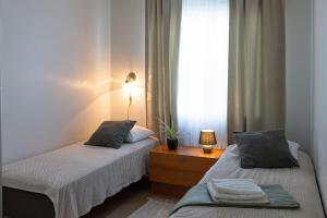 two beds in a small room with a window at 3 bedrooms house with garden in Rauma