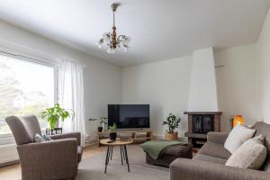 a living room with a couch and a television at 3 bedrooms house with garden in Rauma