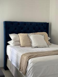 a bed with a blue headboard with pillows on it at M&M Nest in Windhoek +9 photos