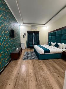 a hotel room with a bed and a television at Hotel de Raj Sialkot in Sialkot +61 photos