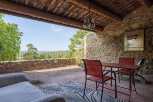 a patio with a table and chairs and a couch at Le Mas D'alzon in Vagnas