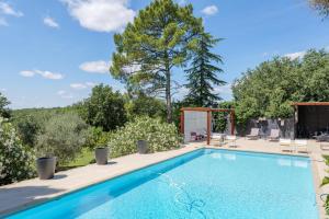 a swimming pool in a yard with trees at Le Mas D'alzon in Vagnas