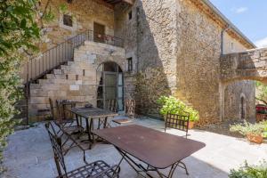 a patio with tables and chairs in front of a building at Le Mas D'alzon in Vagnas