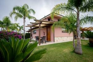 a house with palm trees and a patio at B&B Casale Pietrantica Tropea in Ciaramiti
