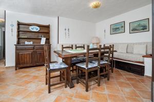 a dining room with a table and chairs and a couch at Brezza Smeralda- Costa Smeralda in Cala Bitta