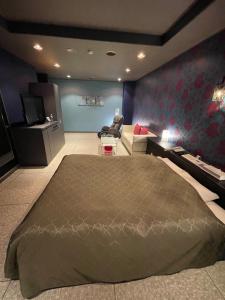 a bedroom with a large bed and a living room at ホテル アクティ エクシブ in Asahi