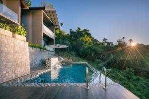 a swimming pool with an umbrella next to a building at Ella 100 View Cottage in Ella