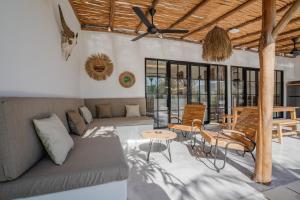 a living room with a couch and a table and chairs at Villa Ruta II - Luxury 2BR Tropical Villa next to Luna Beach Club and Nyanyi beach in Tanah Lot