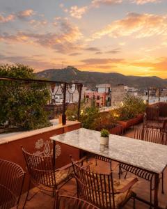 a table and chairs on a balcony with a view at Cozy Den in Jaipur