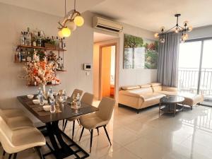 a dining room and living room with a table and chairs at Dear You, Apartment! Saigon - Rivergate Building in Ho Chi Minh City