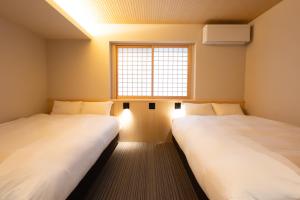two beds in a room with a window at 別府 夕凪 in Beppu +38 photos