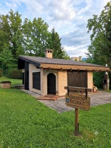 a small brick house with a sign in front of it at LAKEview HAUS in Braslovče
