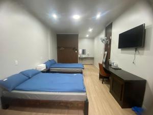 a hotel room with two beds and a television at Lapit Hotel And Apartment in Da Lat