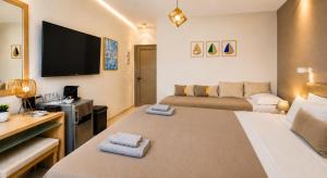 ein Zimmer mit einem Bett, einer Couch und einem Fernseher in der Unterkunft Artemida Pansion Georgioupolis in Kournás