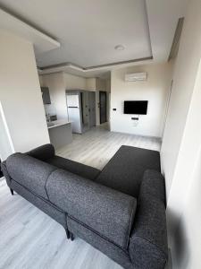 a living room with a couch and a flat screen tv at Ak Suites Rezidans in Trabzon