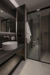 a bathroom with a sink and a glass shower at Union43 Ioannina in Ioannina