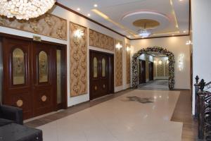 a hallway with wooden doors and a chandelier at Hotel de Raj Sialkot in Sialkot