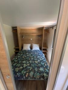 a small bedroom with a bed in a room at Tiny house in Saint-Côme-dʼOlt