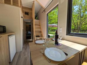 a tiny house with a table with glasses and a bottle of wine at Tiny house in Saint-Côme-dʼOlt