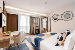 a hotel room with a bed and a desk and a room at Mesona Hotels Blue Hill in Antalya
