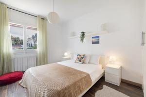 ein weißes Schlafzimmer mit einem Bett und einem Fenster in der Unterkunft Melody in Sitges