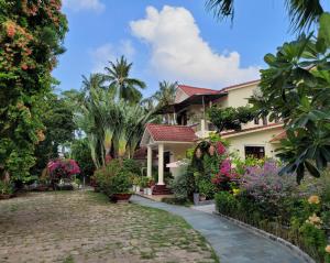 a house with flowers and plants in a yard at Hiep Thanh Resort in Phú Quốc