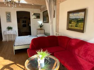 a living room with a red couch and a bed at Staré časy in Chotěboř
