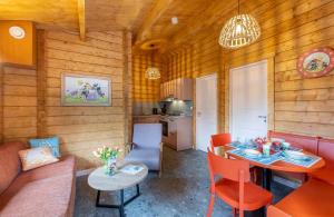 a living room with a table and a kitchen at Familie Resort de Tovertuin in Hoogerheide