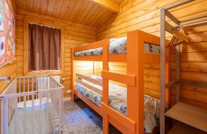 a bedroom with two bunk beds in a log cabin at Familie Resort de Tovertuin in Hoogerheide +28 photos