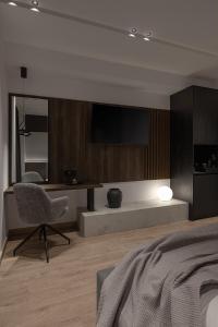a bedroom with a bed and a chair and a television at Union43 Ioannina in Ioannina