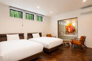 two beds in a room with two windows at Comlien Villa Resort in Tateyama +42 photos