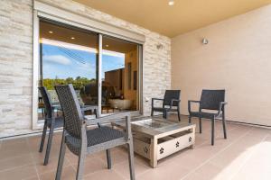 a patio with chairs and a table on a balcony at Comlien Villa Resort in Tateyama