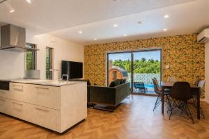 a kitchen and living room with a couch and a table at Comlien Villa Resort in Tateyama