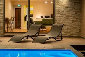 a group of chairs sitting next to a swimming pool at Comlien Villa Resort in Tateyama
