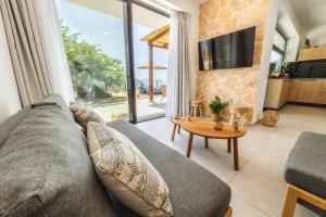 a living room with a couch and a table at ELGIAN Luxury Villa -Private Pool & Sea View in Póndi