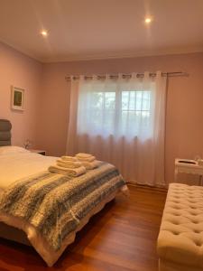 a bedroom with a bed and a window at Camelias in Guimarães