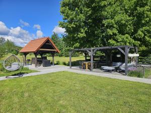 a gazebo with a playground in a park at Słoneczny Ogród - Ekskluzywna posiadłość nad wodą, Grill i Jacuzzi in Krzywińskie
