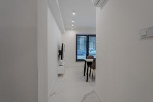 a hallway with white walls and a table and chairs at K16 Apartments in Krakow