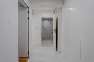 a hallway with white walls and an open door at K16 Apartments in Krakow