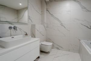 a white bathroom with a sink and a toilet at K16 Apartments in Krakow +78 photos