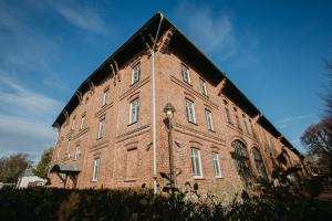 a large red brick building with a black roof at Penzion Albertovec in Opava +10 photos