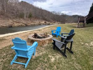 three chairs and a fire pit next to a river at Riverbend Retreat in Todd